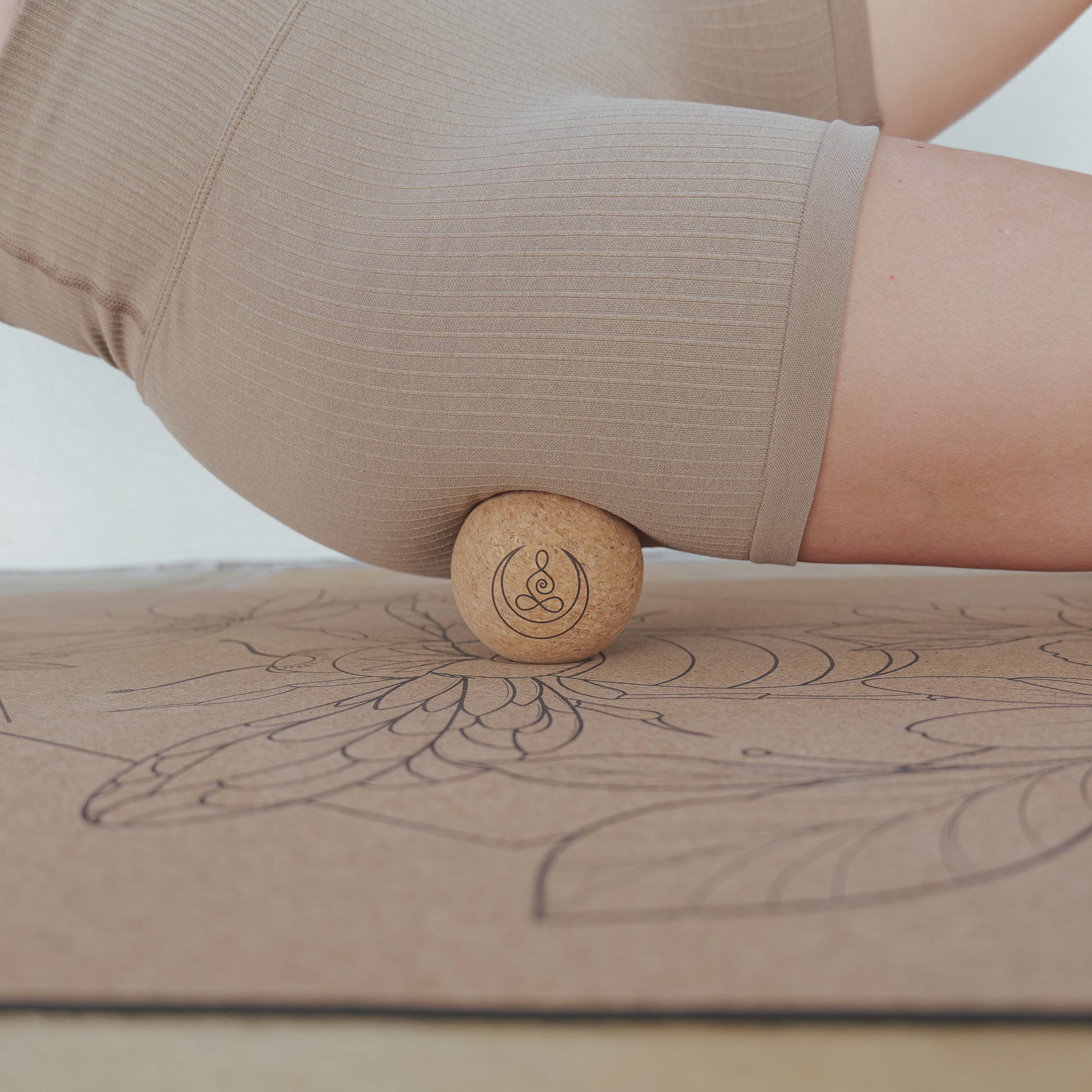 Woman using cork massage balls with OGI NEST logo for single leg.