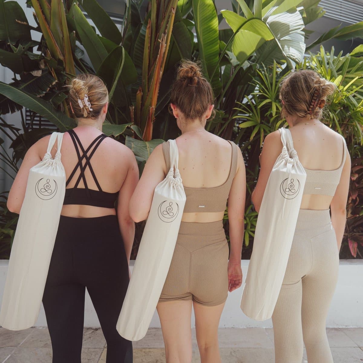 Three women wearing OGI NEST cotton canvas yoga mat carry bags.
